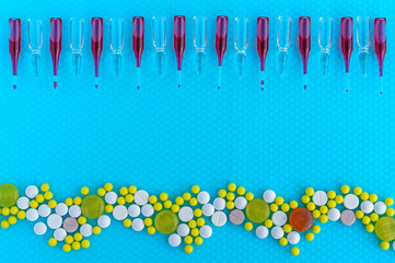Ampoules for injection, pills and vitamins on a blue background. Medical concept.