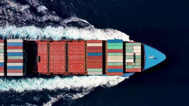 Luftaufnahme eines Container Frachters in voller Fahrt &uuml;ber blauem Ozean