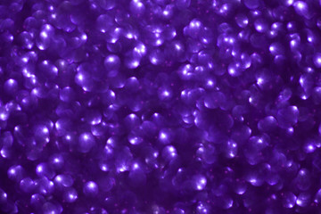 Blurred shiny violet background with sparkling lights.