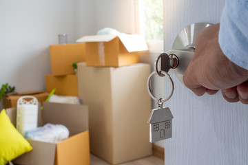 The new home owner opens the door of the room. Inside the room there are personal belongings that are going to be moved to keep correctly. House moving concept.