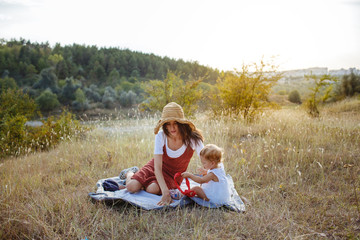 Happy mother and daughter on the field at sunset.