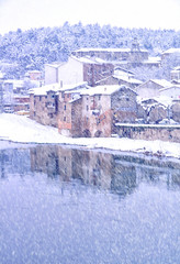 Antiguo y abandonado molino de río en una fuerte nevada blanca junto a rio reflejado © Javier Cordero