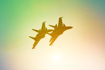 Two aircraft fighter jet airplane sun glow warm yellow orange green gradient sky