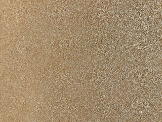 Golden sparkling background from small sequins, closeup. Brilliant backdrop