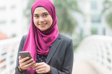 Beautiful Muslim Businesswoman with her Smartphone. Technology and communication concept.