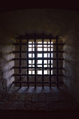  Jail window set in thick walls protected by several bars
