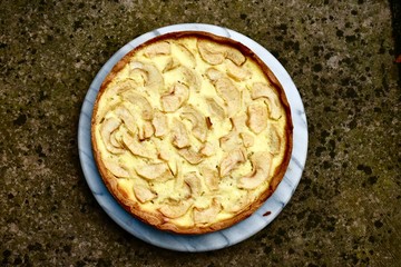 Freshly baked French apple pie with a crunchy bottom on marble plate