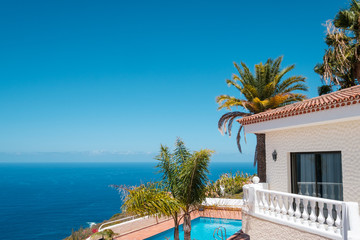 house with swimming pool, palm trees and ocean sea view - obrazy, fototapety, plakaty