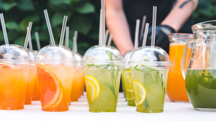 Close-up of glass with citrus lemonade, outdoors. Homemade summer drink concept of healthy food and drink