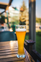 A glass of beer on a wooden table in a restaurant