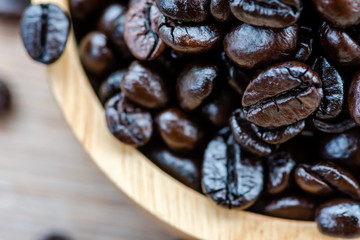 Roasted coffee beans until the coffee beans are black, placed in a wooden bowl.