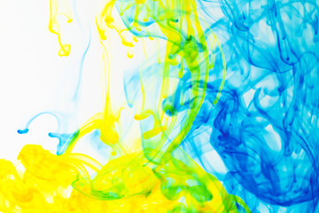flowing yellow and blue ink in water isolated on white background
