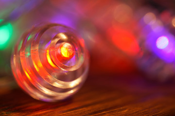 Festive Christmas lights - a garland on a cozy wooden surface. Colorful magic. Close-up. Shallow depth of field.