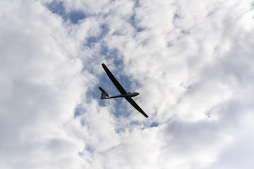 Glider flying against the cloudy sky