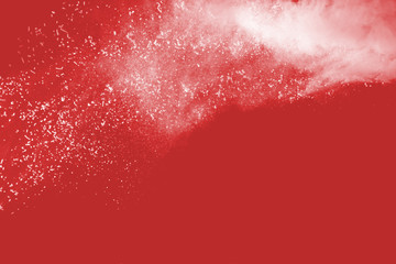 Explosion of colored powder on redbackground