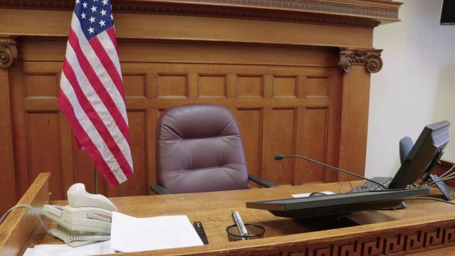 Judge bench and American flag in empty criminal or civil justice courtroom. Prores file, shot in 4K.