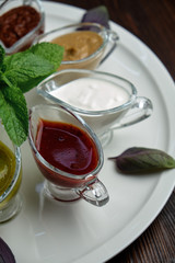 sauces in bowls on a dark wooden background. menu for catering