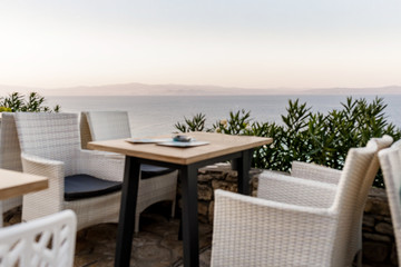 wicker chairs and tables in a summer cafe with sea views. Restaurant sea terrace