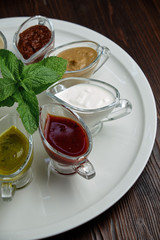 sauces in bowls on a dark wooden background. menu for catering