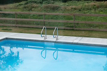 Suburban square swimming pool shot on a cloudy day