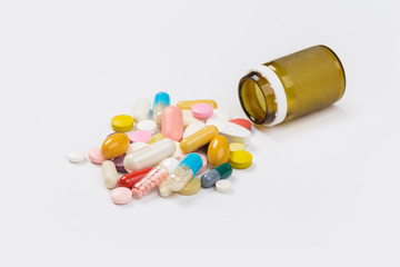Assorted pharmaceutical medicine pills, tablets and capsules.Heap of assorted various medicine tablets and pills different colors on white background. Top view.Copy space