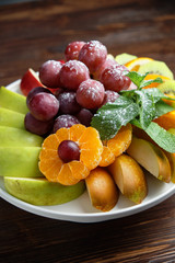 Sliced fruits on a white plate . catering menu