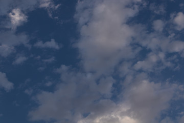 Fototapeta premium gray clouds against a blue sky through which the sun's rays are trying to break through