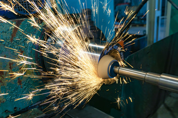 Grinding operations with an end abrasive wheel on a circular grinding machine with sparks.