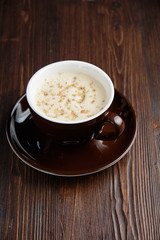 Cappuccino on a brown wooden background. Menu