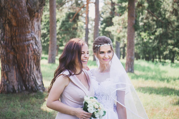 Bride and bridesmaid in the park, close-up