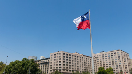 Chileans walking near the giant flag on Avenida La Alameda with the citizenship Square, in downtown Santiago de Chile. Chile.