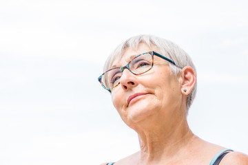 older woman with White hair and glasses, 65 years, happy expression