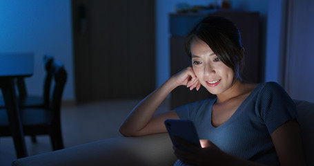 Obraz premium Woman look at mobile phone at night