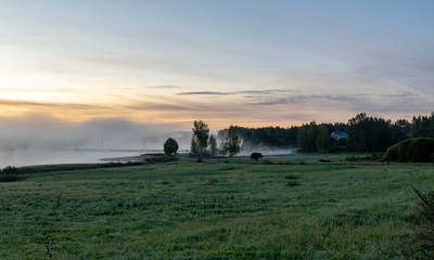 Fototapeta premium Landscape with beautiful morning mist on the lake in the distance. Forest, lake, fog. Mysterious mist