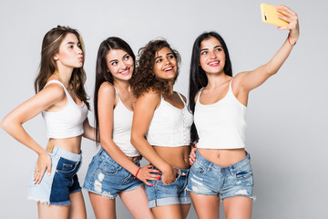 Four girlfriends make selfies isolated on white background