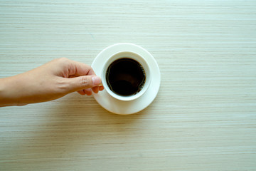 Female hands holding cups of coffee