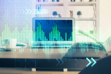 Financial graph colorful drawing and table with computer on background. Multi exposure. Concept of international markets.