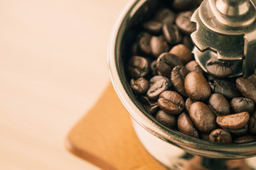 Vintage manual coffee grinder with roasted coffee beans