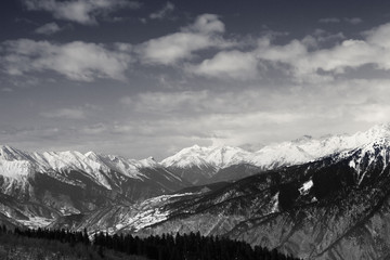 Snowy mountains and sky with clouds at winter sun day