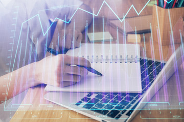 Financial charts displayed on woman's hand taking notes background. Concept of research. Double exposure