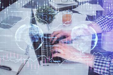 Double exposure of graph with man typing on computer in office on background. Concept of hard work.