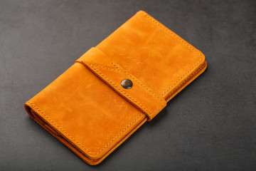 Wallet made of genuine brown nubuck leather on a dark background. Handmade leather items