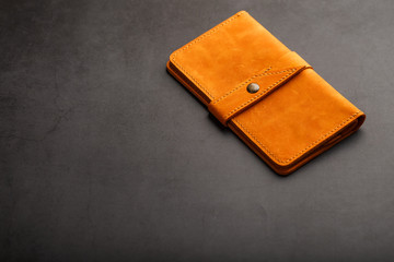 Wallet made of genuine brown nubuck leather on a dark background. Handmade leather items