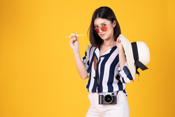 Tourist woman in summer casual clothes.Asian Smiling woman .Passenger traveling abroad to travel on yellow background.Asian woman going to summer vacation.Travel trip funny.