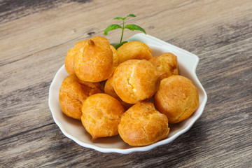 Sweet tasty profiteroles heap in the bowl