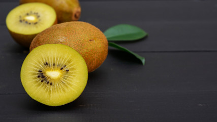 Golden kiwi on a black wooden table.