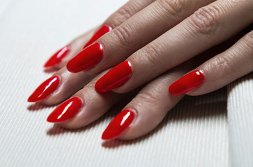 applying red gel nail polish on women's nails