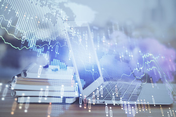 Stock market graph on background with desk and personal computer. Double exposure. Concept of financial analysis.