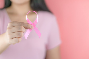 Healthcare, medicine and breast cancer awareness concept. Closeup on woman chest with pink breast cancer awareness ribbon.