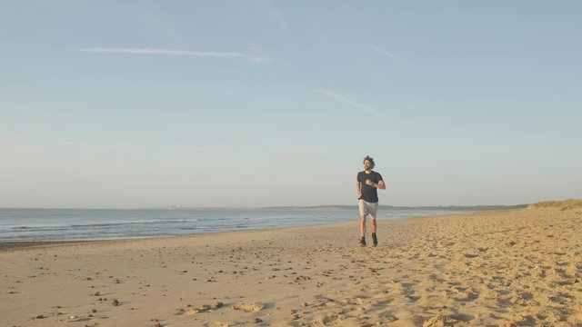 Jogging on the beach at sunrise 4K